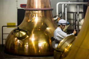 A worker takes a sample from a spirit still at Suntory Holdings' Yamazaki Distillery in Shimamoto town, Osaka prefecture, near Kyoto, December 1, 2014. Nestled at the foot of wooded hills near the ancient Japanese capital of Kyoto, the Yamazaki whisky distillery feels a long way from the northerly glens of Scotch's spiritual home. Despite its unlikely birthplace, last month Yamazaki's Single Malt Sherry Cask 2013 trumped more than a thousand challengers to be named the world's best whisky by leading critic Jim Murray in his Whisky Bible 2015. Picture taken December 1, 2014. To match story JAPAN-WHISKY/ REUTERS/Thomas Peter (JAPAN - Tags: BUSINESS)